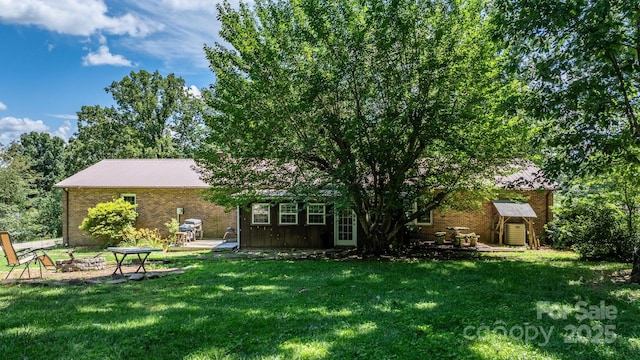 1560 Lafayette Ave, Hudson, NC 28638 - rear view of house with a fire pit, a yard, and brick siding