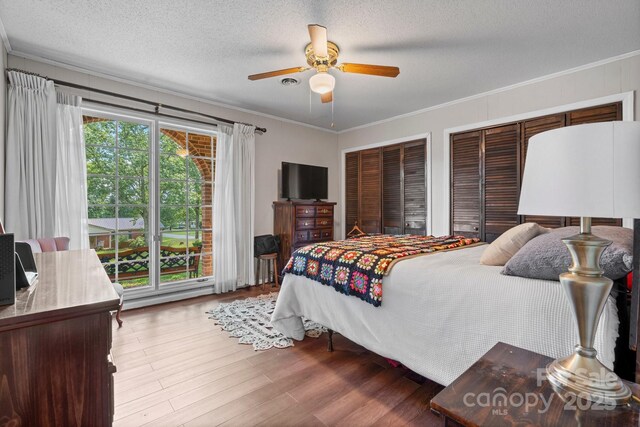 1560 Lafayette Ave, Hudson, NC 28638 - bedroom with ornamental molding, a textured ceiling, wood finished floors, multiple closets, and ceiling fan