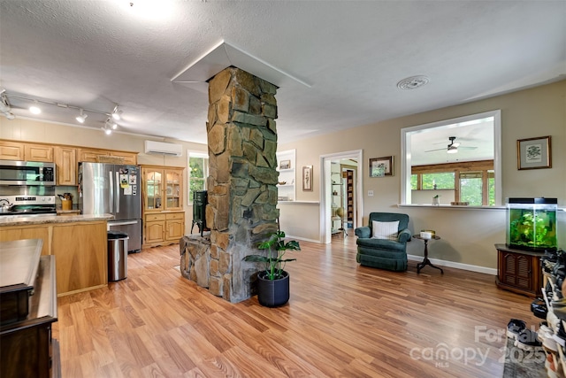 590 Claude Cook Rd, Sylva, NC 28779 - living area with ornate columns, a wall mounted air conditioner, light wood-type flooring, a ceiling fan, and a textured ceiling
