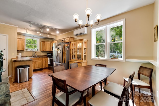 590 Claude Cook Rd, Sylva, NC 28779 - dining room with a wall unit AC, light wood-type flooring, and a chandelier