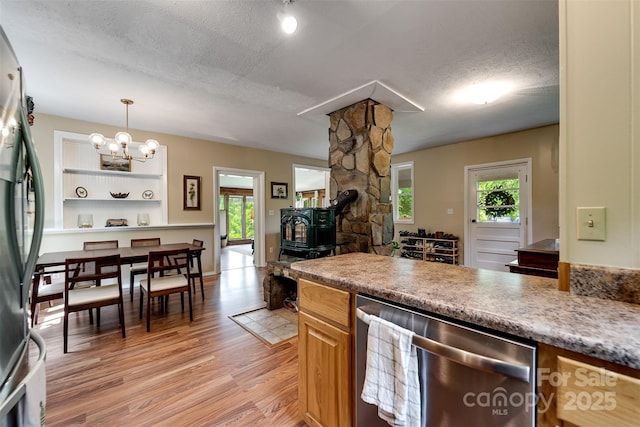 590 Claude Cook Rd, Sylva, NC 28779 - kitchen featuring stainless steel appliances, light wood-type flooring, a chandelier, a wood stove, and a textured ceiling