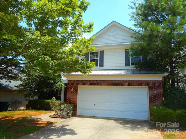 15321 Superior St, Charlotte, NC 28273 - view of front of home with concrete driveway, a standing seam roof, an attached garage, a metal roof, and brick siding