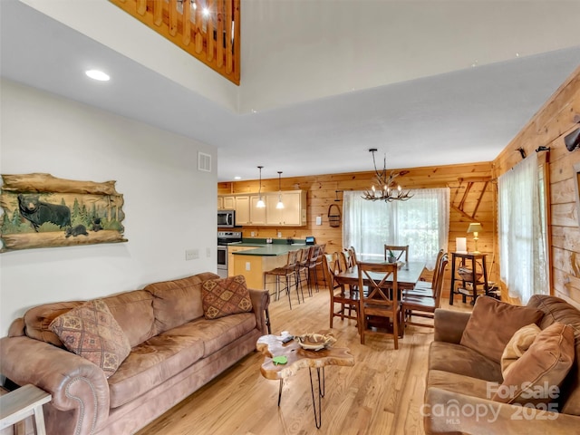 1064 Point Of View Dr, Waynesville, NC 28785 - living area featuring light wood-style floors, wood walls, recessed lighting, a chandelier, and a towering ceiling