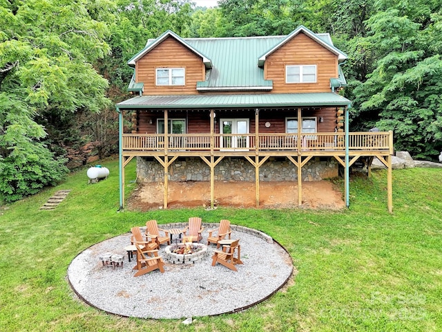 1064 Point Of View Dr, Waynesville, NC 28785 - rear view of house featuring an outdoor fire pit, a lawn, a metal roof, and a wooden deck