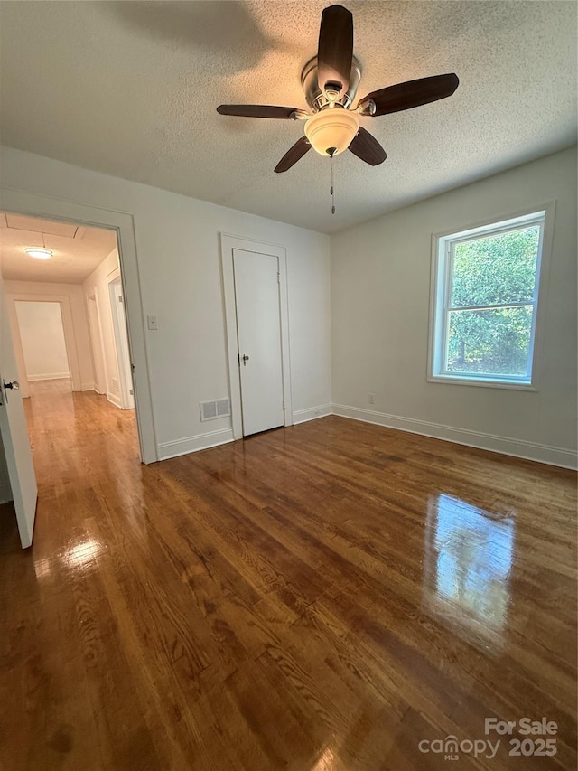 727 3rd Ave NW, Hickory, NC 28601 - unfurnished bedroom with attic access, wood finished floors, a textured ceiling, and a ceiling fan
