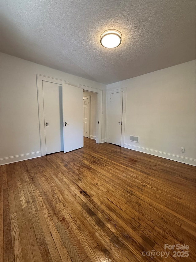 727 3rd Ave NW, Hickory, NC 28601 - unfurnished bedroom featuring dark wood-type flooring and a textured ceiling