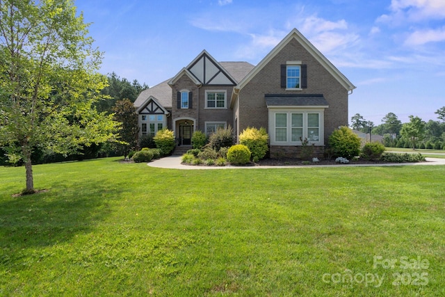 805 Hidden Pond Ln, Waxhaw, NC 28173 - tudor home featuring a front yard and brick siding
