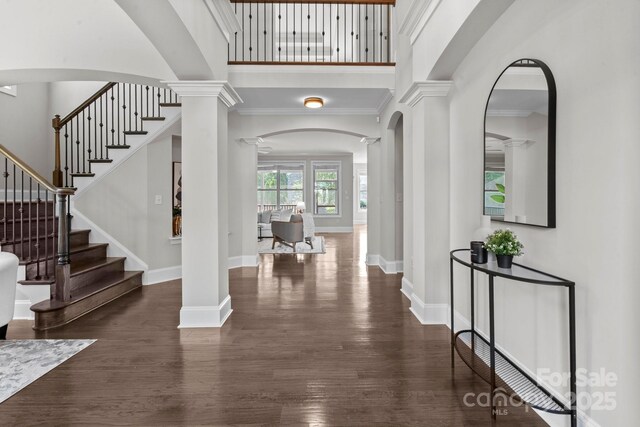 805 Hidden Pond Ln, Waxhaw, NC 28173 - foyer entrance with decorative columns, a high ceiling, wood finished floors, stairway, and arched walkways
