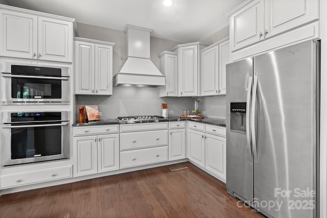 805 Hidden Pond Ln, Waxhaw, NC 28173 - kitchen with stainless steel appliances, premium range hood, dark countertops, and dark wood-style floors