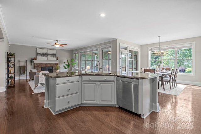 805 Hidden Pond Ln, Waxhaw, NC 28173 - kitchen with dishwasher, a glass covered fireplace, ceiling fan, dark wood-style floors, and healthy amount of natural light