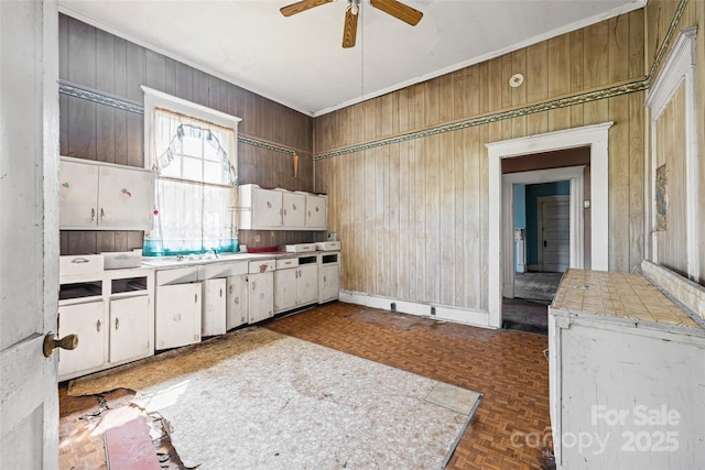 108 Walker St, Chester, SC 29706 - kitchen featuring a ceiling fan, wood walls, white cabinetry, tile counters, and crown molding