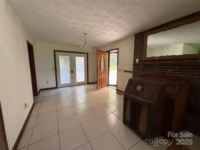 5422 River Rd, Granite Falls, NC 28630 - unfurnished dining area with a textured ceiling, a chandelier, light tile patterned floors, and french doors