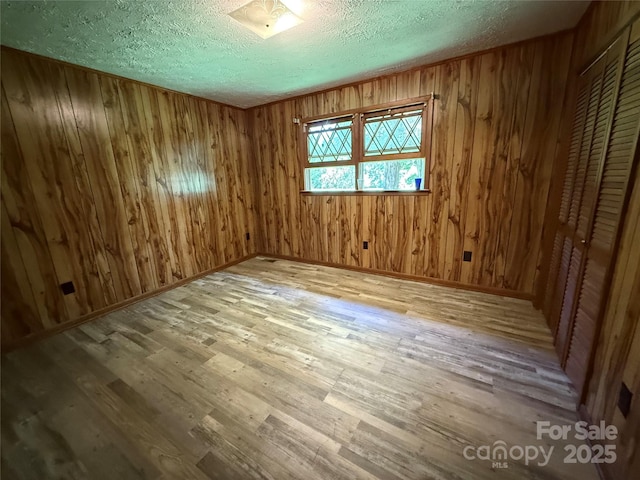 5422 River Rd, Granite Falls, NC 28630 - empty room with wood finished floors, a textured ceiling, and wood walls