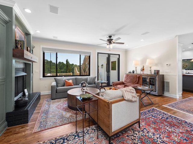 724 Moore Rd, Tryon, NC 28782 - living room featuring a fireplace with raised hearth, wood finished floors, ceiling fan, ornamental molding, and recessed lighting