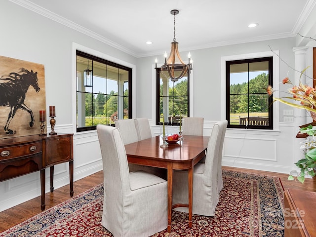 724 Moore Rd, Tryon, NC 28782 - dining area featuring a chandelier, wood finished floors, healthy amount of natural light, a decorative wall, and crown molding