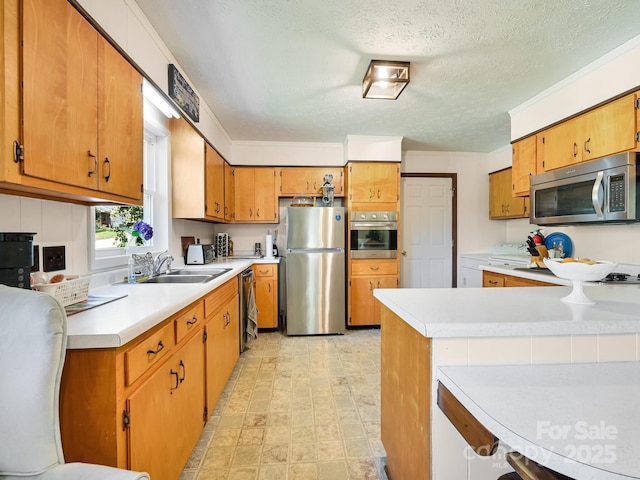85 Pine Ridge Rd, Mars Hill, NC 28754 - kitchen featuring appliances with stainless steel finishes, washer / clothes dryer, light countertops, brown cabinetry, and a textured ceiling