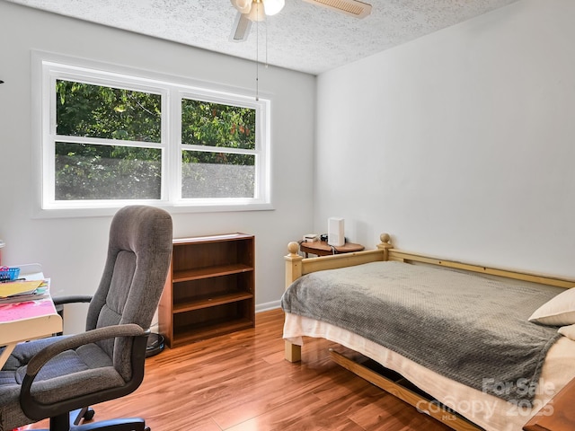 85 Pine Ridge Rd, Mars Hill, NC 28754 - bedroom with multiple windows, wood finished floors, a textured ceiling, an office area, and a ceiling fan