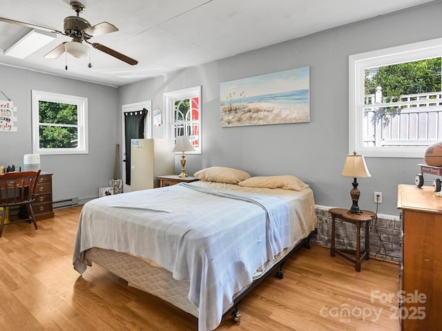 85 Pine Ridge Rd, Mars Hill, NC 28754 - bedroom featuring light wood-type flooring, a baseboard heating unit, and ceiling fan