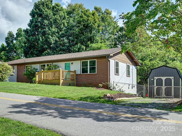 85 Pine Ridge Rd, Mars Hill, NC 28754 - ranch-style house with a storage unit, brick siding, a front lawn, and a deck