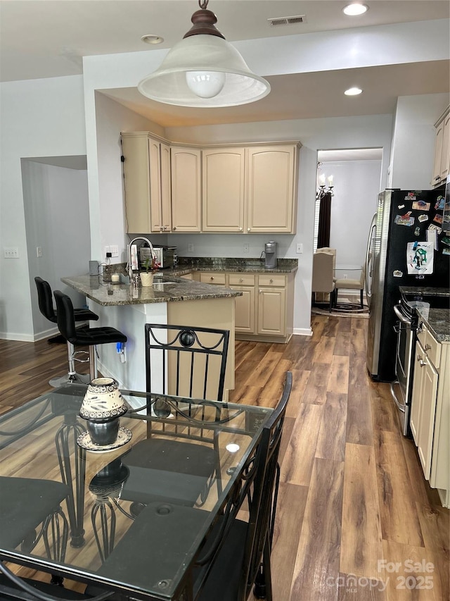 630 Springhouse Pl, Clover, SC 29710 - kitchen featuring a peninsula, stainless steel range with electric stovetop, wood finished floors, dark stone counters, and recessed lighting