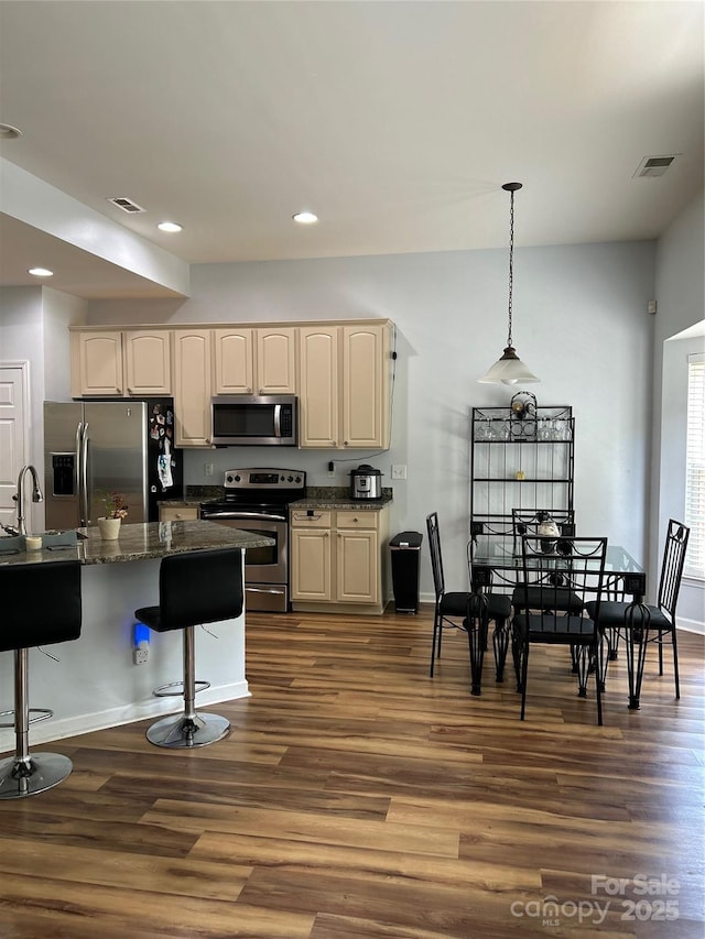 630 Springhouse Pl, Clover, SC 29710 - kitchen with appliances with stainless steel finishes, a breakfast bar area, dark wood finished floors, recessed lighting, and pendant lighting