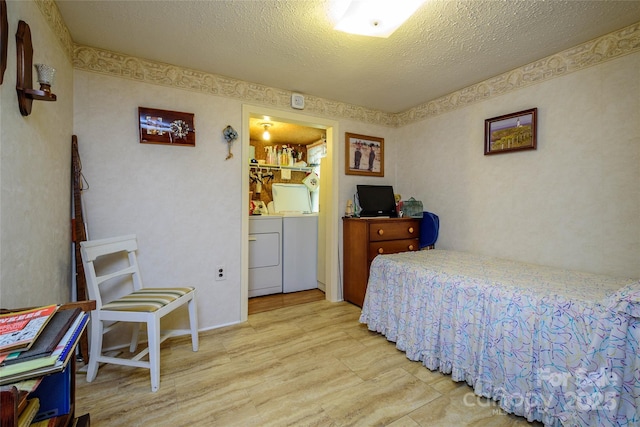4720 Brevard Rd, Horse Shoe, NC 28742 - bedroom with washer and dryer, wood finished floors, and a textured ceiling