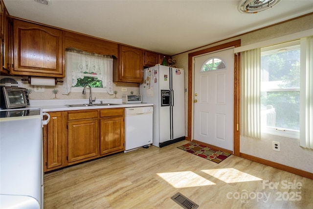 4720 Brevard Rd, Horse Shoe, NC 28742 - kitchen featuring white appliances, light wood-style flooring, brown cabinets, and light countertops