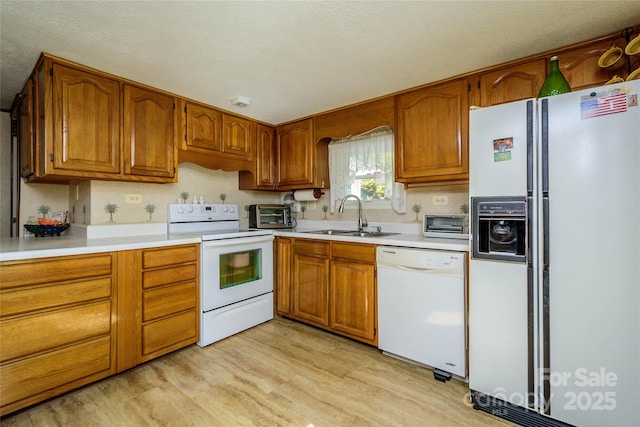 4720 Brevard Rd, Horse Shoe, NC 28742 - kitchen featuring white appliances, brown cabinetry, light wood-type flooring, and light countertops