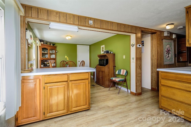 4720 Brevard Rd, Horse Shoe, NC 28742 - kitchen with light wood-type flooring, a peninsula, light countertops, and wooden walls