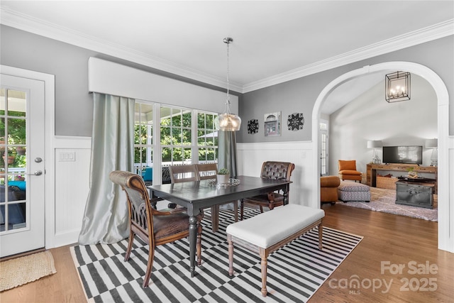 9012 Arrington Manor Pl, Charlotte, NC 28277 - dining space featuring arched walkways, ornamental molding, healthy amount of natural light, wainscoting, and wood finished floors