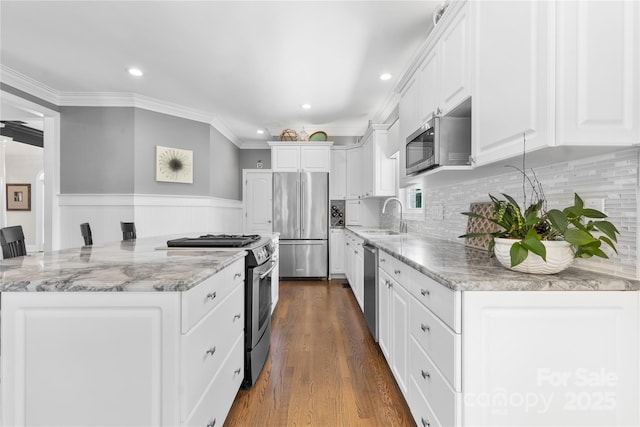 9012 Arrington Manor Pl, Charlotte, NC 28277 - kitchen featuring appliances with stainless steel finishes, white cabinetry, light stone counters, dark wood-style floors, and a wainscoted wall