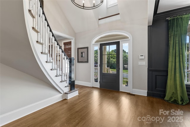 9012 Arrington Manor Pl, Charlotte, NC 28277 - entryway featuring wood finished floors, a chandelier, stairs, and high vaulted ceiling