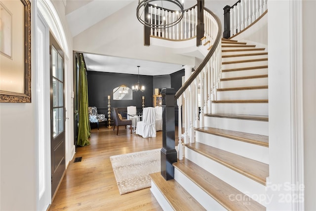 9012 Arrington Manor Pl, Charlotte, NC 28277 - foyer entrance featuring a chandelier, stairs, wood finished floors, and vaulted ceiling