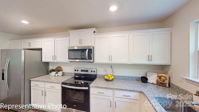 1053 20th Avenue Loop SE, Hickory, NC 28602 - kitchen with stainless steel appliances, white cabinets, recessed lighting, and light stone countertops