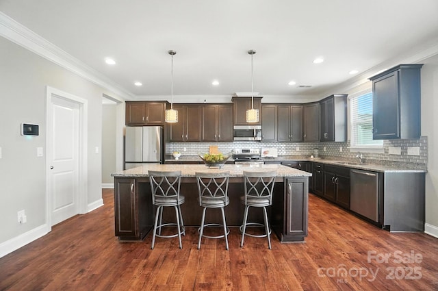2006 Paddington Dr, Indian Trail, NC 28079 - kitchen with appliances with stainless steel finishes, ornamental molding, a center island, backsplash, and dark wood-style floors