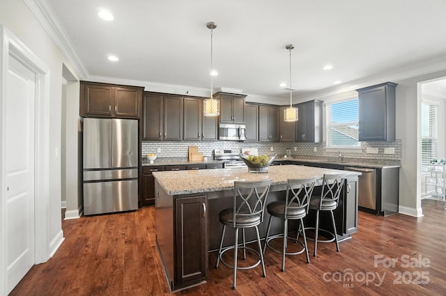 2006 Paddington Dr, Indian Trail, NC 28079 - kitchen featuring stainless steel appliances, a center island, tasteful backsplash, crown molding, and dark wood finished floors