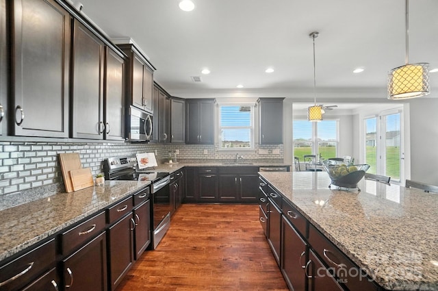 2006 Paddington Dr, Indian Trail, NC 28079 - kitchen featuring stainless steel appliances, light stone counters, a center island, decorative backsplash, and recessed lighting