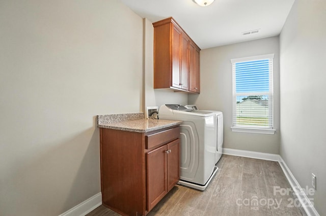 2006 Paddington Dr, Indian Trail, NC 28079 - laundry area with cabinet space, washer and clothes dryer, and light wood-style flooring