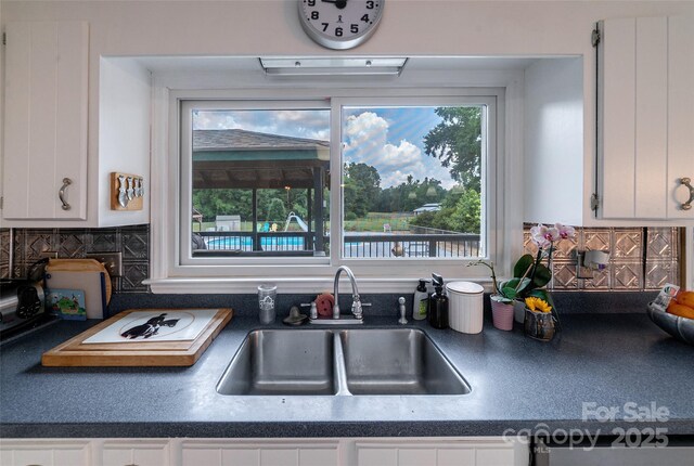7411 Davis Rd, Waxhaw, NC 28173 - kitchen featuring healthy amount of natural light, white cabinets, backsplash, and dark countertops