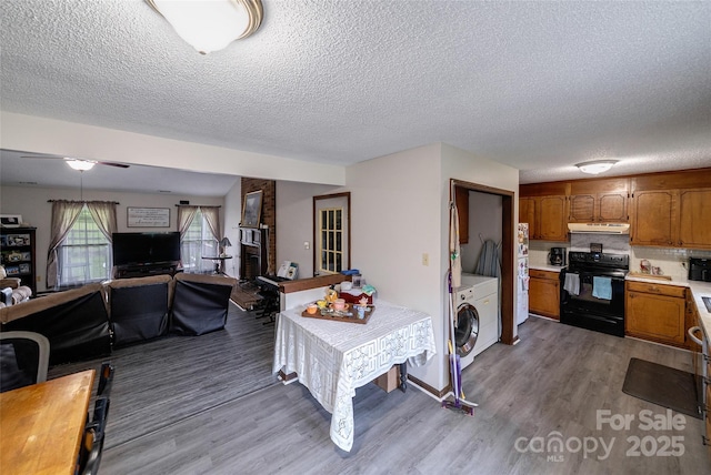 7411 Davis Rd, Waxhaw, NC 28173 - kitchen featuring black electric range oven, open floor plan, light countertops, wood finished floors, and a textured ceiling