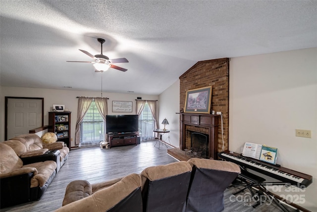 7411 Davis Rd, Waxhaw, NC 28173 - living area featuring a fireplace, ceiling fan, wood finished floors, a textured ceiling, and vaulted ceiling