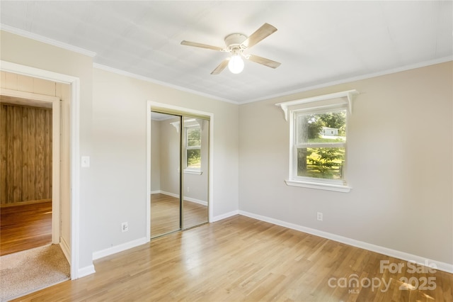 735 Edmiston Rd, Mount Ulla, NC 28125 - unfurnished bedroom featuring multiple windows, a closet, light wood finished floors, ornamental molding, and a ceiling fan
