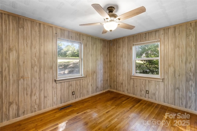 735 Edmiston Rd, Mount Ulla, NC 28125 - spare room featuring healthy amount of natural light, hardwood / wood-style floors, ceiling fan, and wooden walls