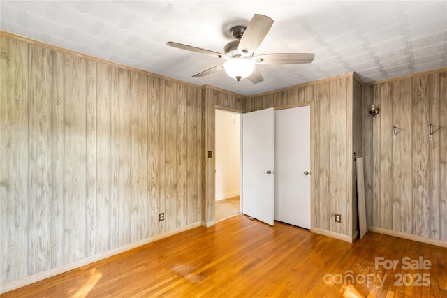 735 Edmiston Rd, Mount Ulla, NC 28125 - unfurnished bedroom featuring wooden walls, wood finished floors, and ceiling fan