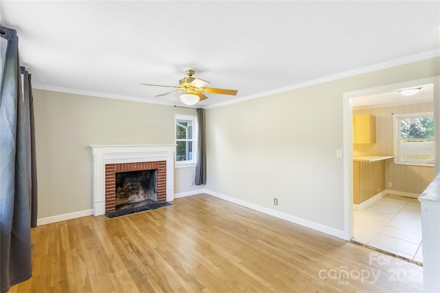 735 Edmiston Rd, Mount Ulla, NC 28125 - unfurnished living room featuring ceiling fan, light wood-style flooring, a brick fireplace, and crown molding