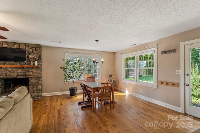 4 Northview Ln, Weaverville, NC 28787 - dining area with a textured ceiling, hardwood / wood-style flooring, ceiling fan, a chandelier, and a stone fireplace