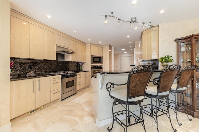 5 Hidden Cove Ln, Clover, SC 29710 - kitchen featuring stainless steel appliances, light brown cabinetry, under cabinet range hood, a kitchen breakfast bar, and recessed lighting