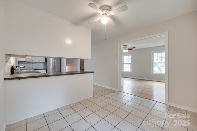 810 Applegate Ct, Gastonia, NC 28054 - kitchen featuring freestanding refrigerator, dark countertops, decorative backsplash, ceiling fan, and light tile patterned floors