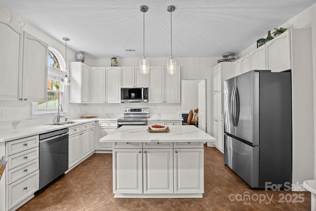 4108 Deerfield Dr NW, Concord, NC 28027 - kitchen featuring appliances with stainless steel finishes, a kitchen island, and white cabinetry