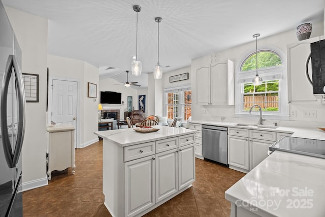 4108 Deerfield Dr NW, Concord, NC 28027 - kitchen with appliances with stainless steel finishes, a fireplace, a ceiling fan, and white cabinets
